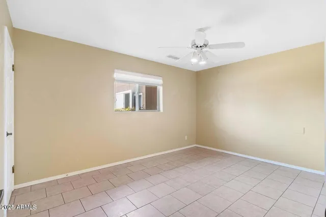 an empty room with a ceiling fan and a window