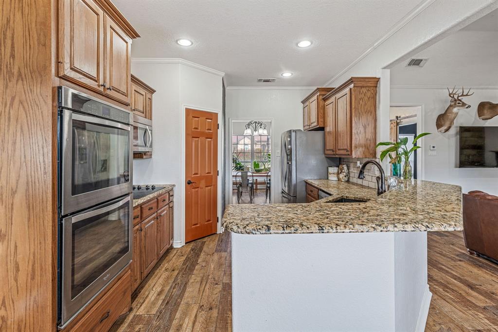 112 Blue Ribbon Lane Stephenville, TX 76401 - Photo 11 of 31 a kitchen with stainless steel appliances granite countertop a refrigerator and a sink