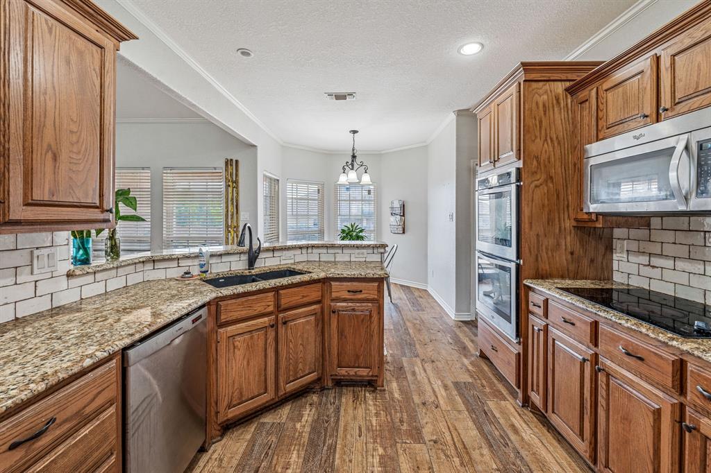 112 Blue Ribbon Lane Stephenville, TX 76401 - Photo 13 of 31 a large kitchen with stainless steel appliances granite countertop a sink stove and refrigerator