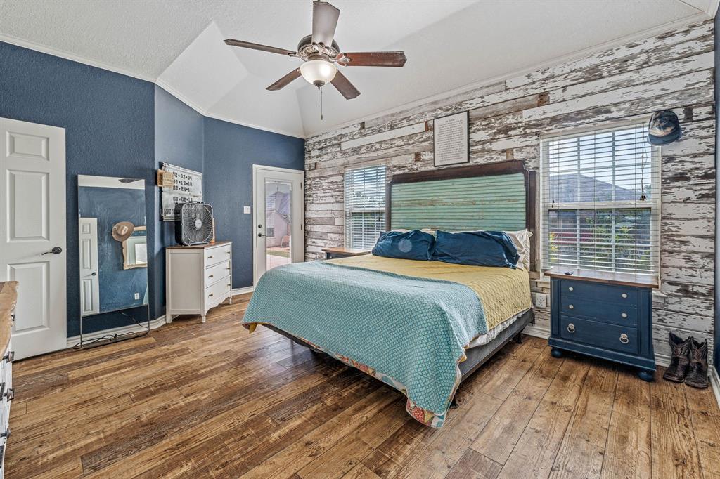 112 Blue Ribbon Lane Stephenville, TX 76401 - Photo 16 of 31 a bedroom with a large bed a flat tv screen and dresser