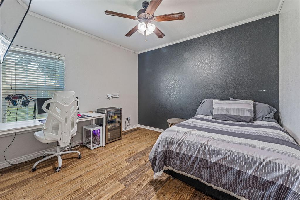 112 Blue Ribbon Lane Stephenville, TX 76401 - Photo 20 of 31 a bedroom with a bed a desk and chair with wooden floor