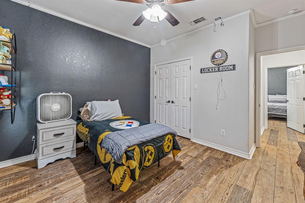 112 Blue Ribbon Lane Stephenville, TX 76401 - Photo 23 of 31 a bedroom with a bed and a chandelier