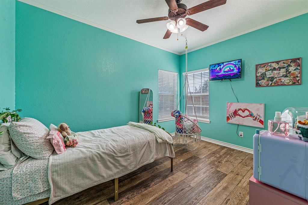 112 Blue Ribbon Lane Stephenville, TX 76401 - Photo 25 of 31 a bedroom with a bed and a chandelier