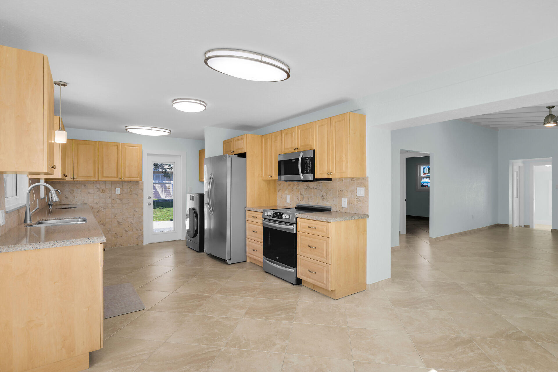 251 Azalea Street Tavernier, FL 33070 - Photo 12 of 58 a kitchen with stainless steel appliances granite countertop a sink stove and refrigerator