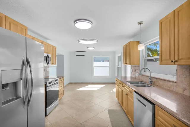 a kitchen with stainless steel appliances granite countertop a sink and refrigerator