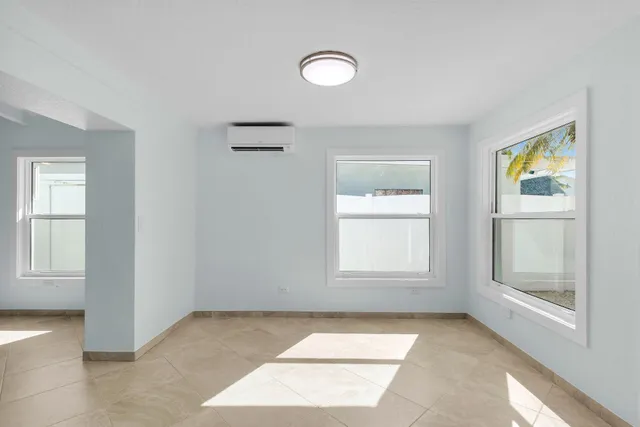 an empty room with a ceiling fan and a window