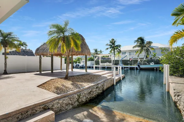 a view of a house with a patio and a yard