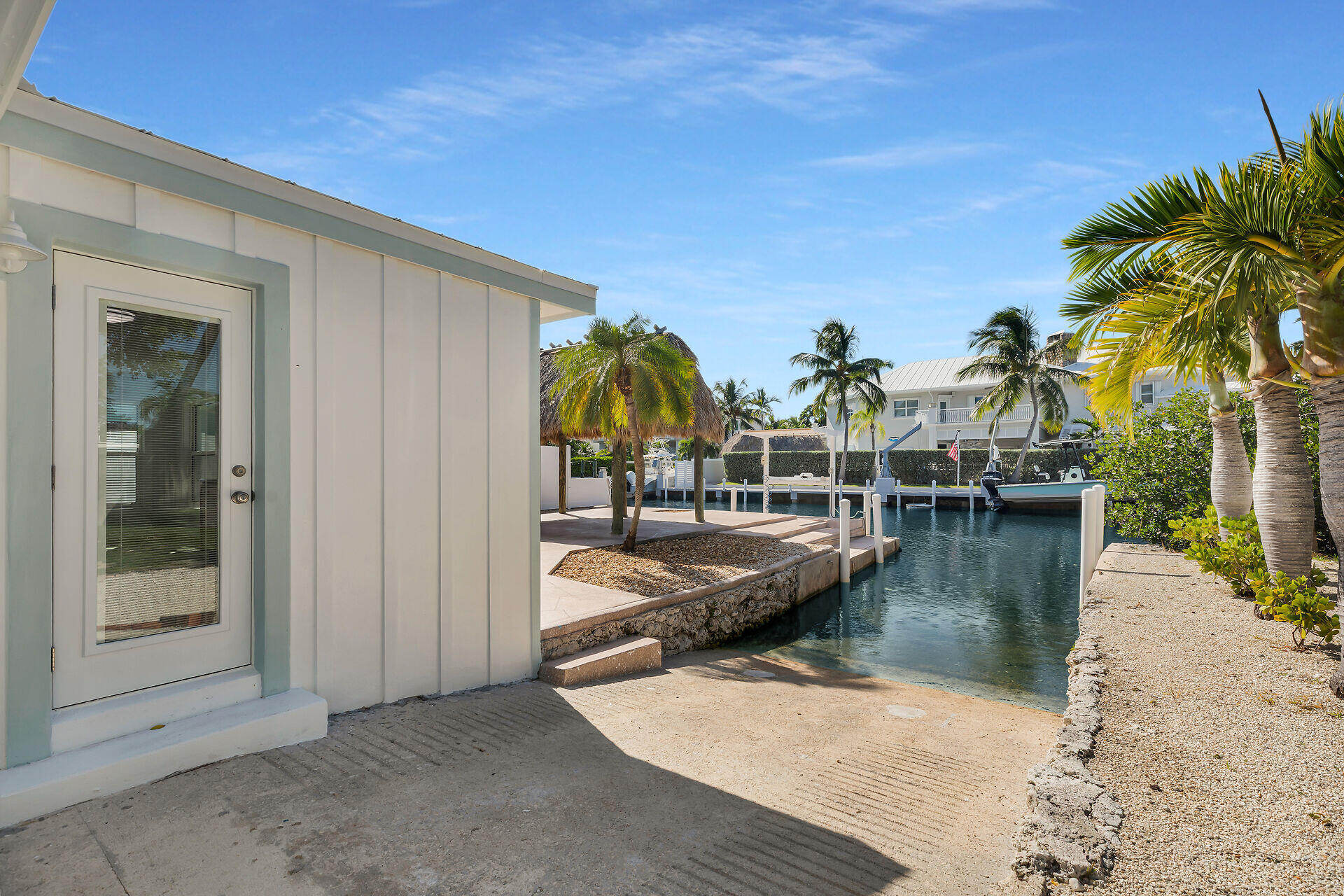 251 Azalea Street Tavernier, FL 33070 - Photo 43 of 58 a view of a swimming pool with a lawn chairs under palm tree