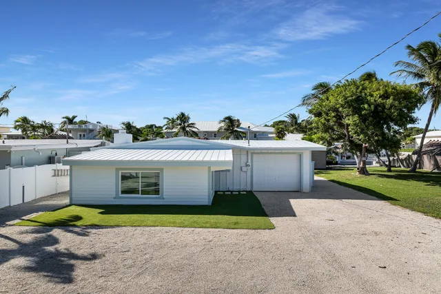 a view of a house with backyard and trees