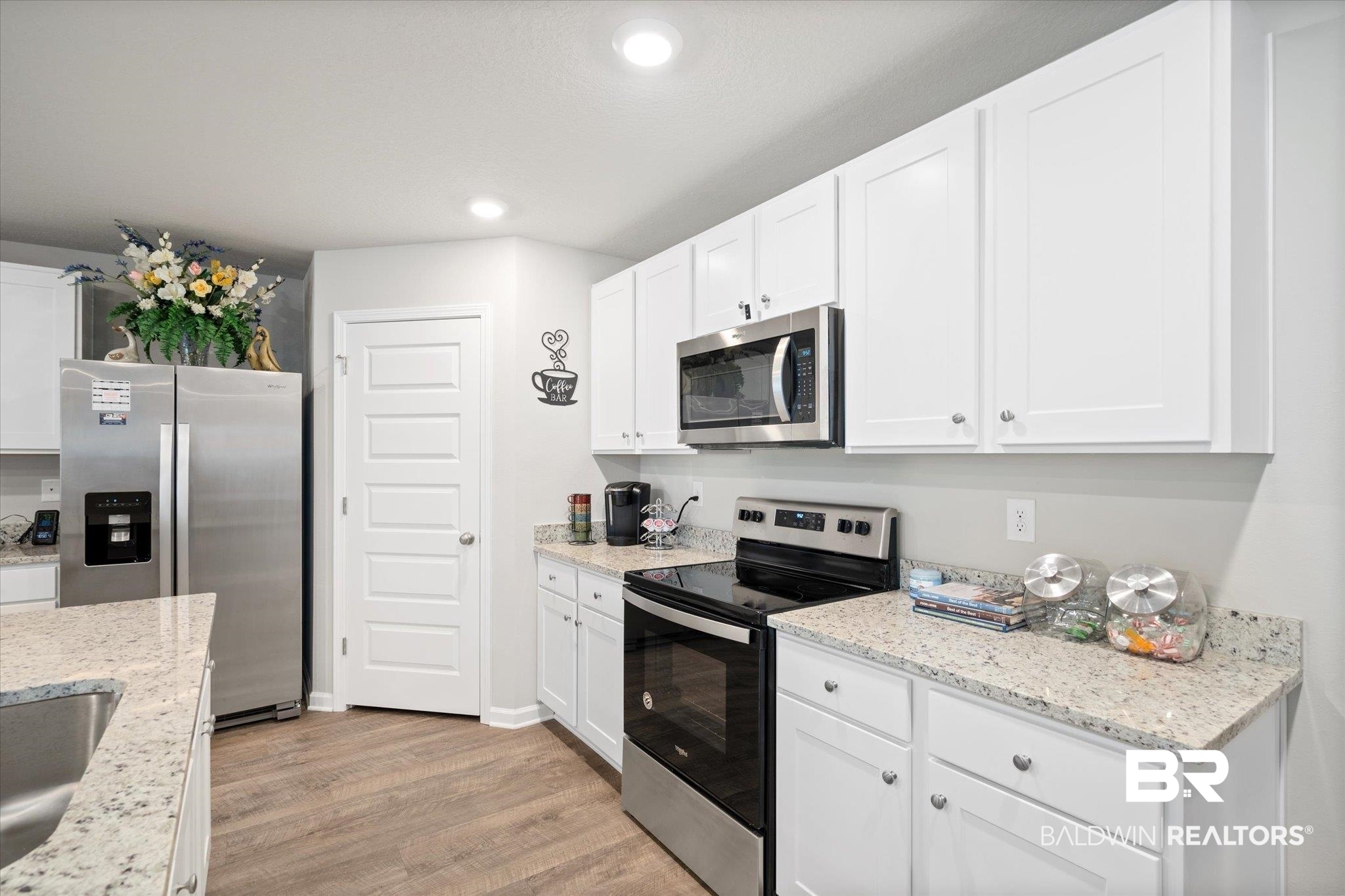 446 Paget Drive East Mobile, AL 36608 - Photo 5 of 20 Kitchen with white cabinets, light hardwood / wood-style floors, light stone counters, and stainless steel appliances