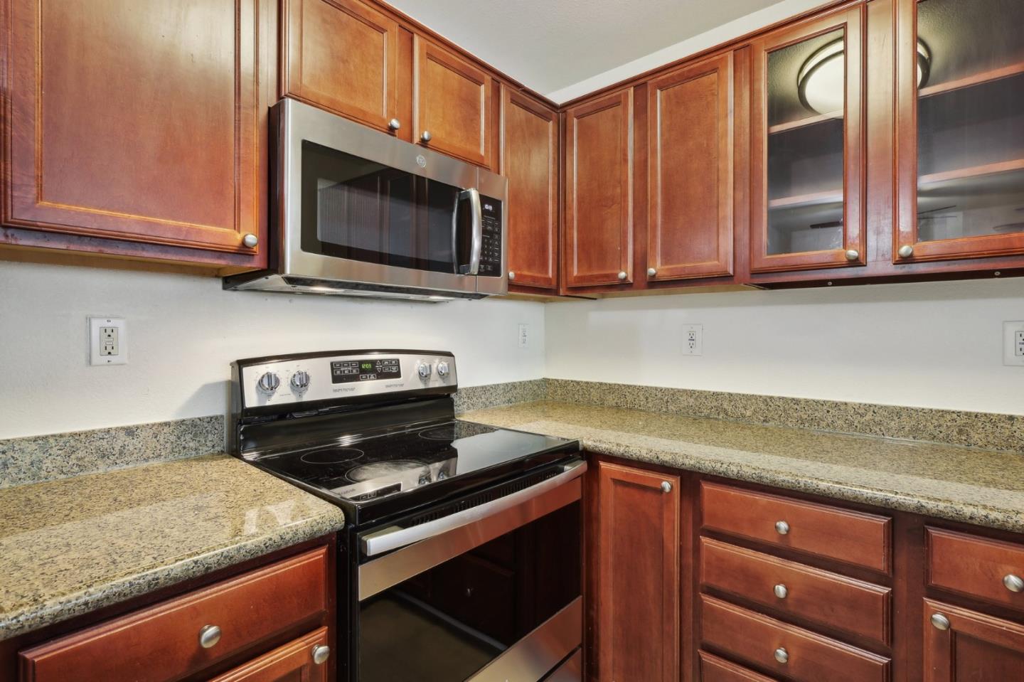 492 Dempsey Road, Unit 194 Milpitas, CA 95035 - Photo 12 of 27 a kitchen with wooden cabinets and a stove top oven