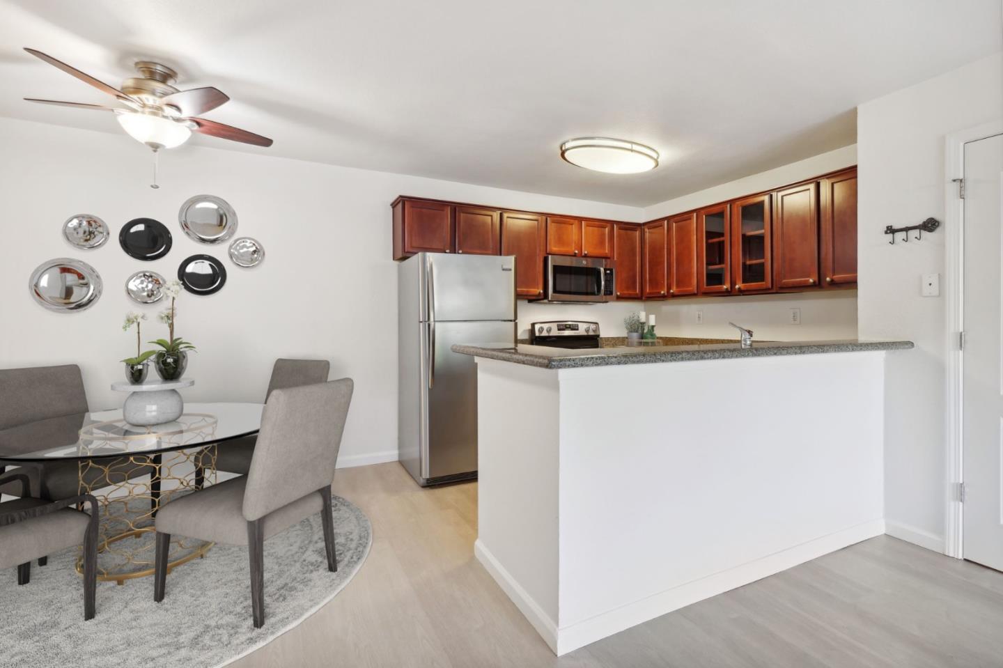 492 Dempsey Road, Unit 194 Milpitas, CA 95035 - Photo 7 of 27 a kitchen with stainless steel appliances granite countertop a stove a refrigerator a sink a dining table and chairs with wooden floor
