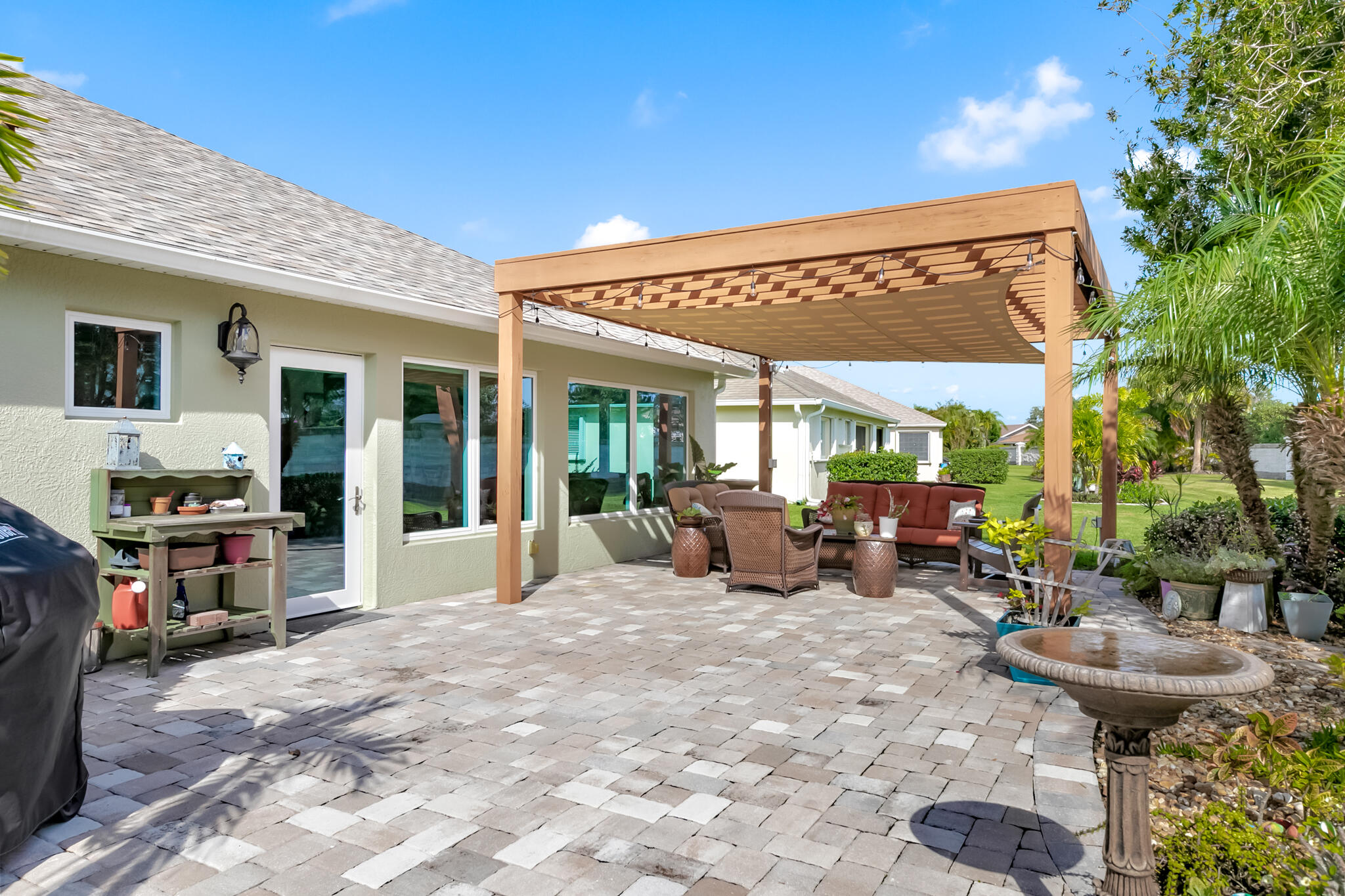 1605 Boca Rio Drive Melbourne, FL 32940 - Photo 30 of 55 a view of a patio with table and chairs potted plants and large tree