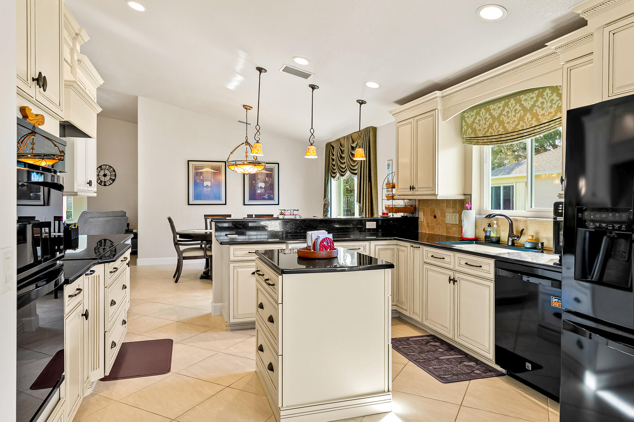 1605 Boca Rio Drive Melbourne, FL 32940 - Photo 7 of 55 a kitchen with stainless steel appliances kitchen island granite countertop a stove top oven a sink dishwasher and white cabinets with wooden floor