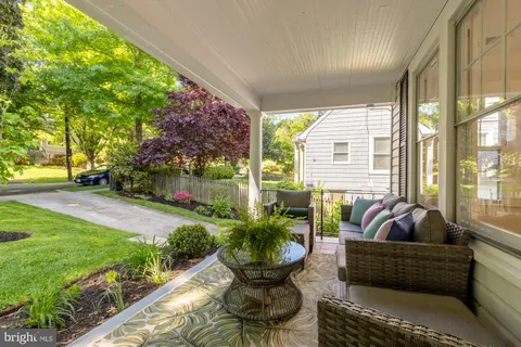 a living room with patio furniture and a garden