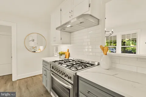 a kitchen with a stove and a wooden floor