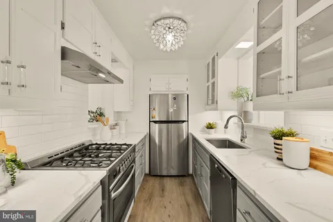 a kitchen with a sink stainless steel appliances a counter space and cabinets