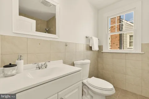 a bathroom with a sink a toilet and a mirror
