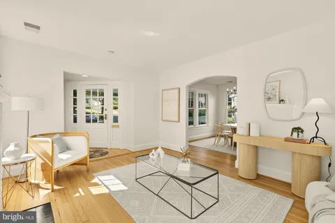 a living room with furniture a rug and white walls