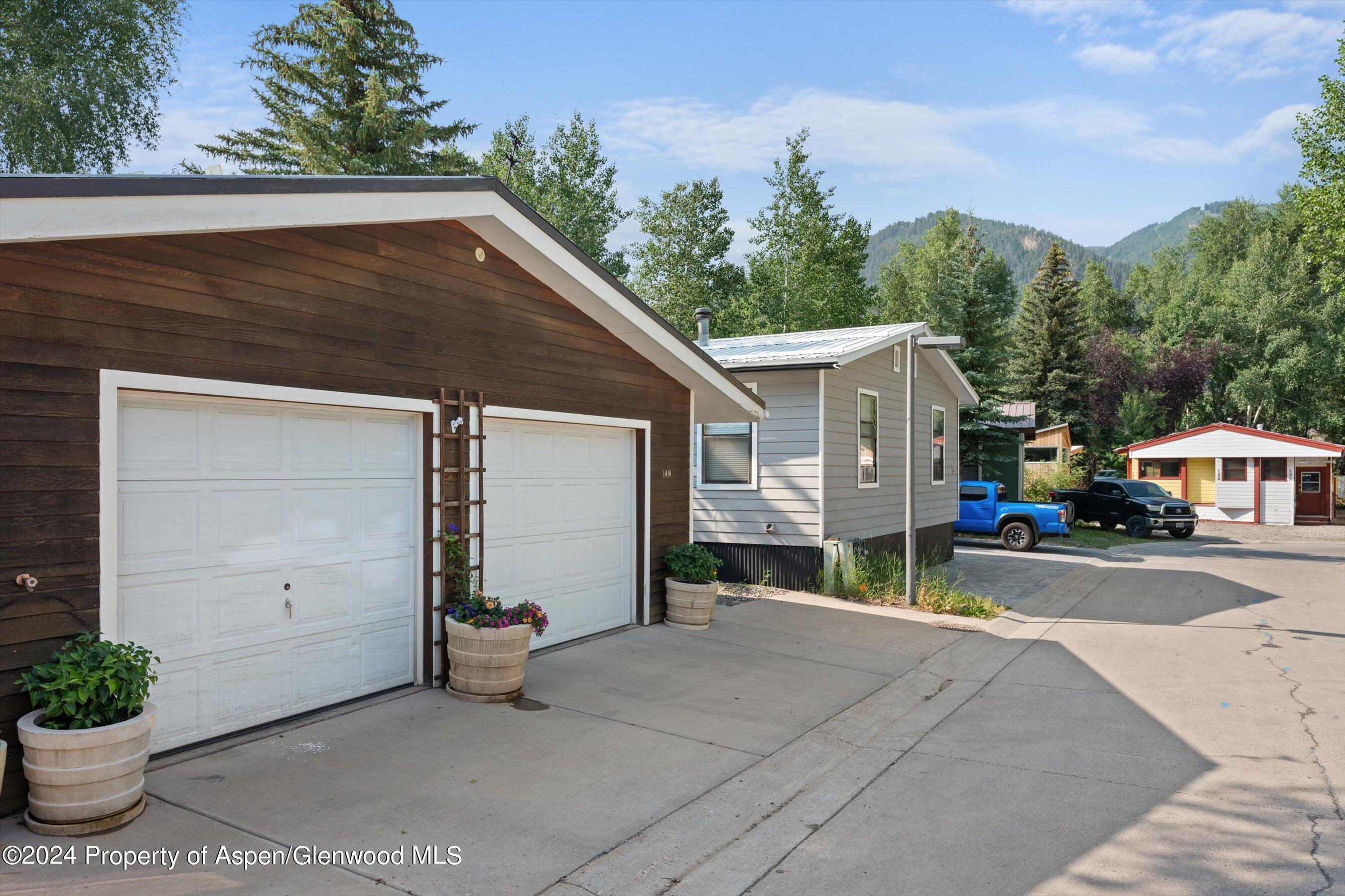 140 Maple Lane Aspen, CO 81611 - Photo 36 of 37 a backyard of a house with potted plants and trees