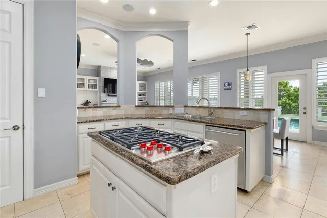 a kitchen with stainless steel appliances granite countertop a stove a sink and a refrigerator
