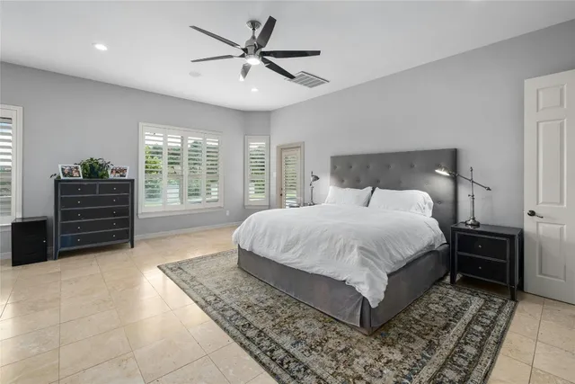 a spacious bedroom with a bed and a chandelier