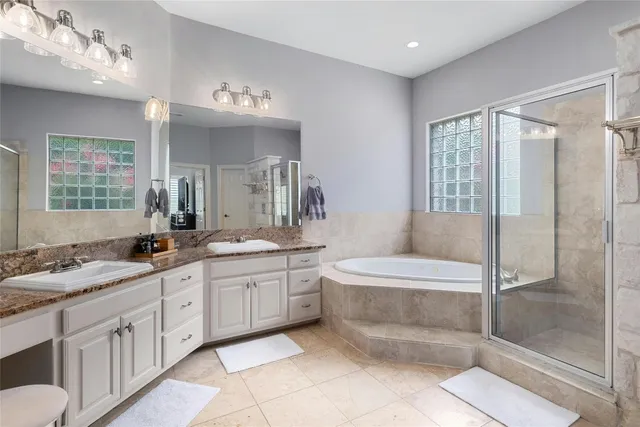 a spacious bathroom with a double vanity sink a large mirror and a bathtub
