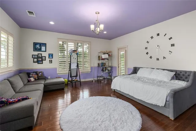 a spacious bedroom with a bed a couch and large window