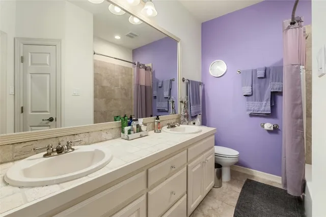 a bathroom with a double vanity sink mirror and toilet