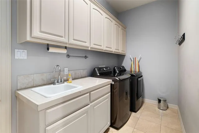 a utility room with sink dryer and washer