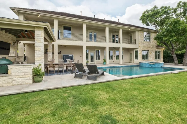 a front view of a house with swimming pool and sitting area