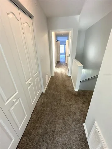 an empty room with windows and ceiling fan