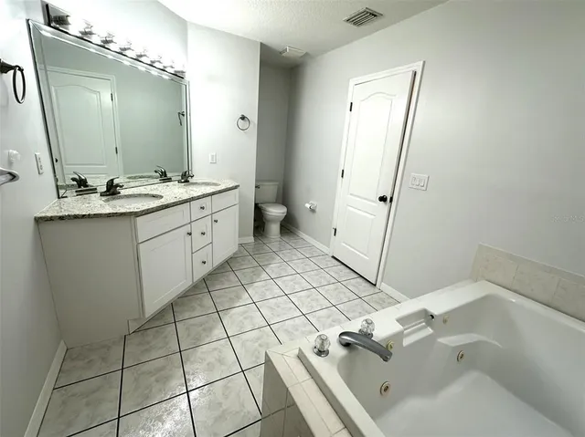 a spacious bathroom with a tub sink and mirror