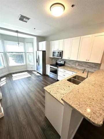 a kitchen with a sink a stove and cabinets