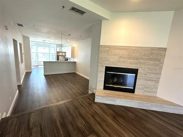 an empty room with wooden floor and a fireplace