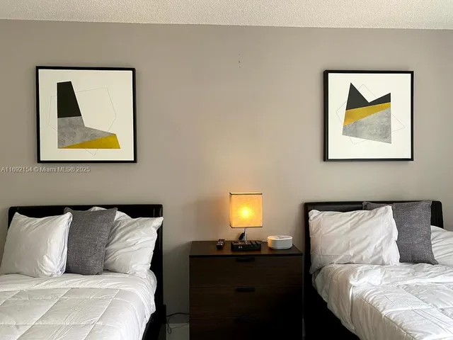 a bed room with a bed and painting on the wall