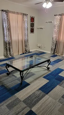 a living room with a table and paintings on the wall