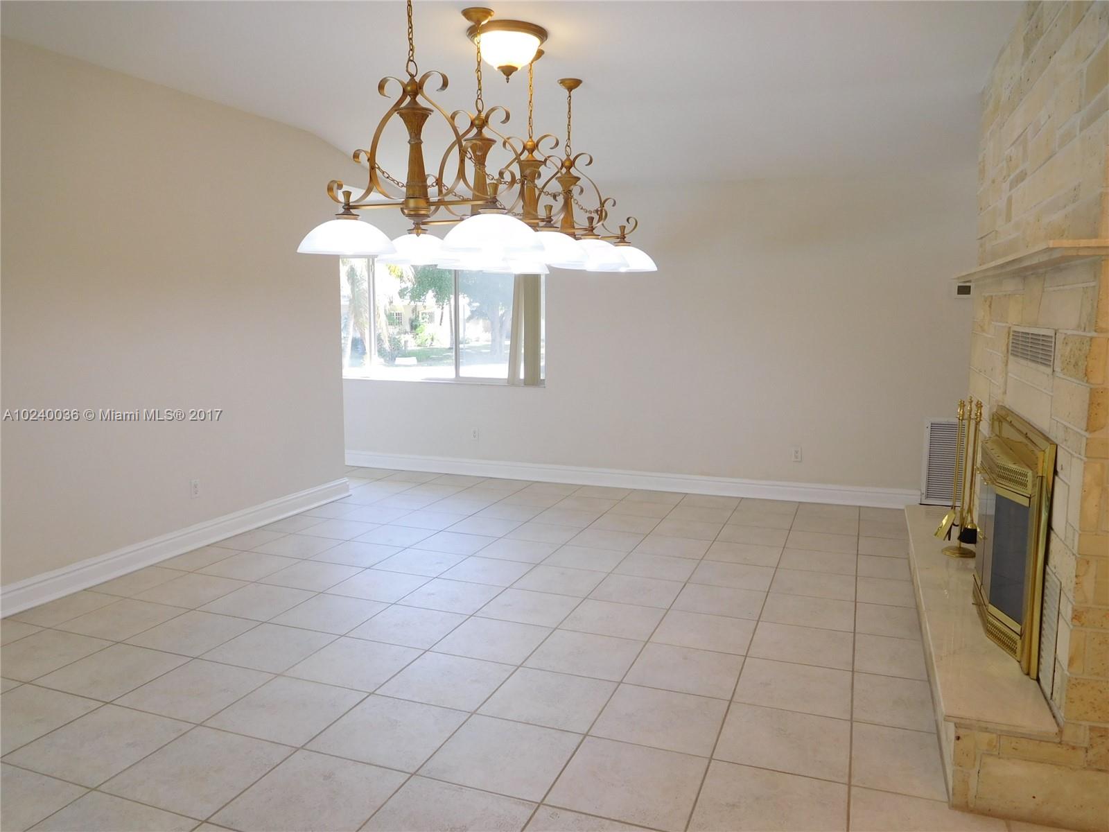 14441 Snapper Drive Coral Gables, FL 33158 - Photo 7 of 27 an empty room with a fireplace and chandelier