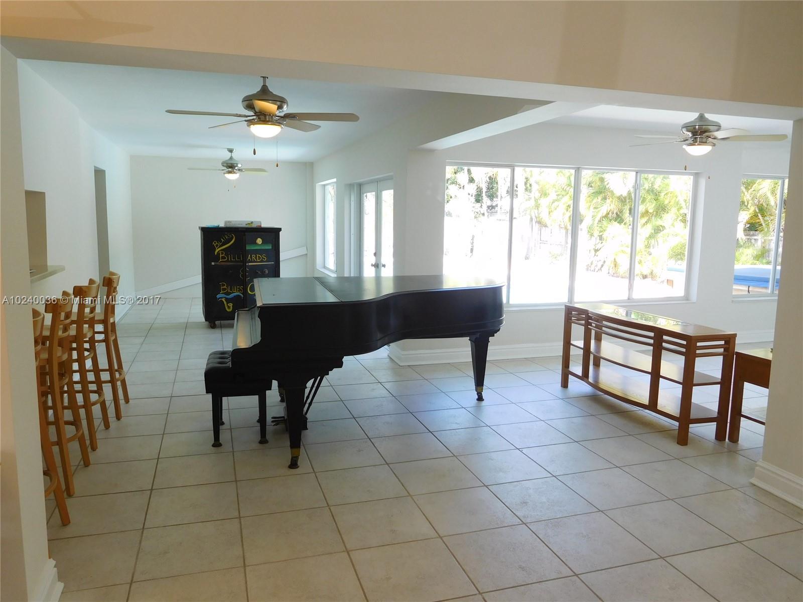 14441 Snapper Drive Coral Gables, FL 33158 - Photo 9 of 27 a living room with furniture a dining table and a fireplace