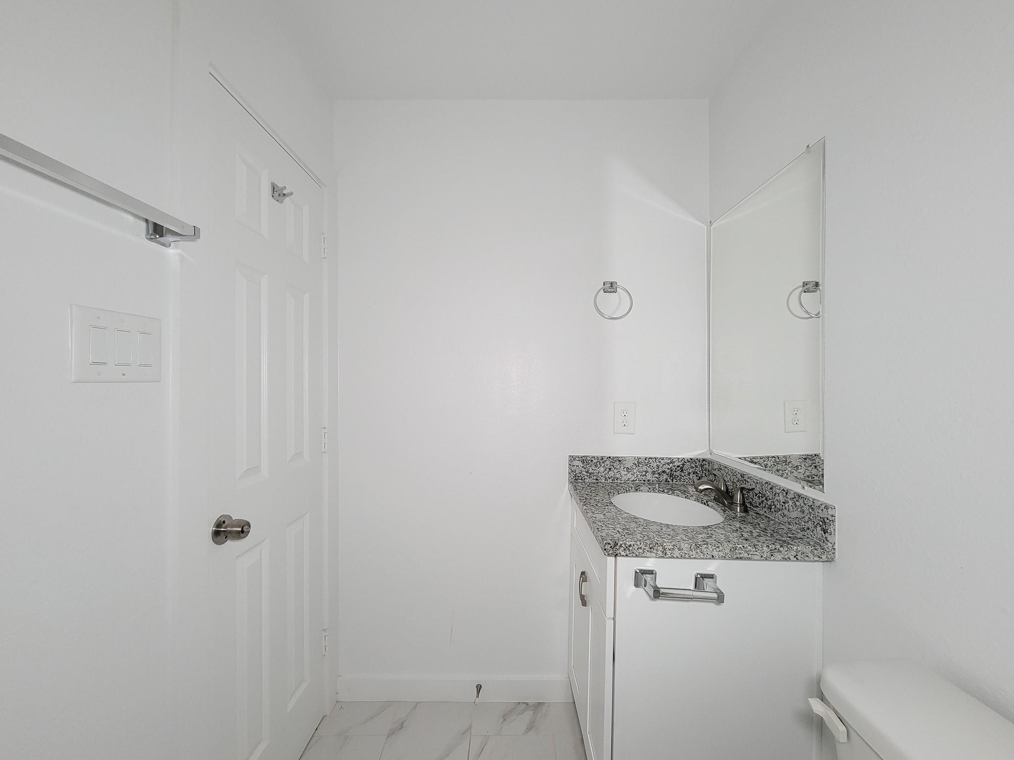 8122 Sterlingshire Street, Unit B Houston, TX 77078 - Photo 20 of 27 a bathroom with a granite countertop sink and mirror