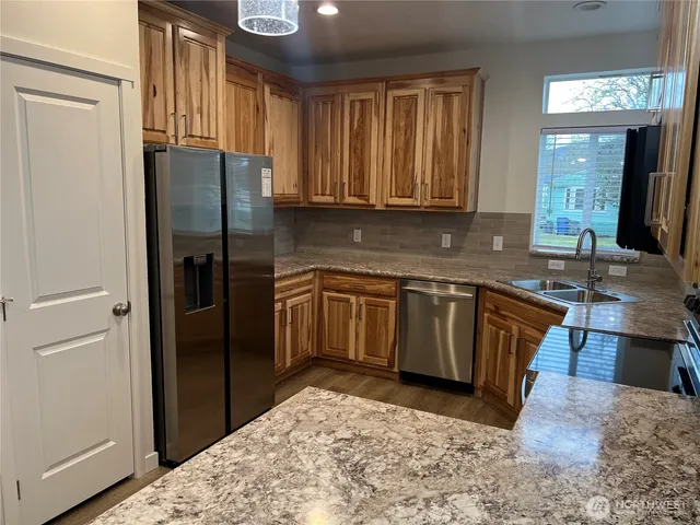 a kitchen with a refrigerator sink and cabinets