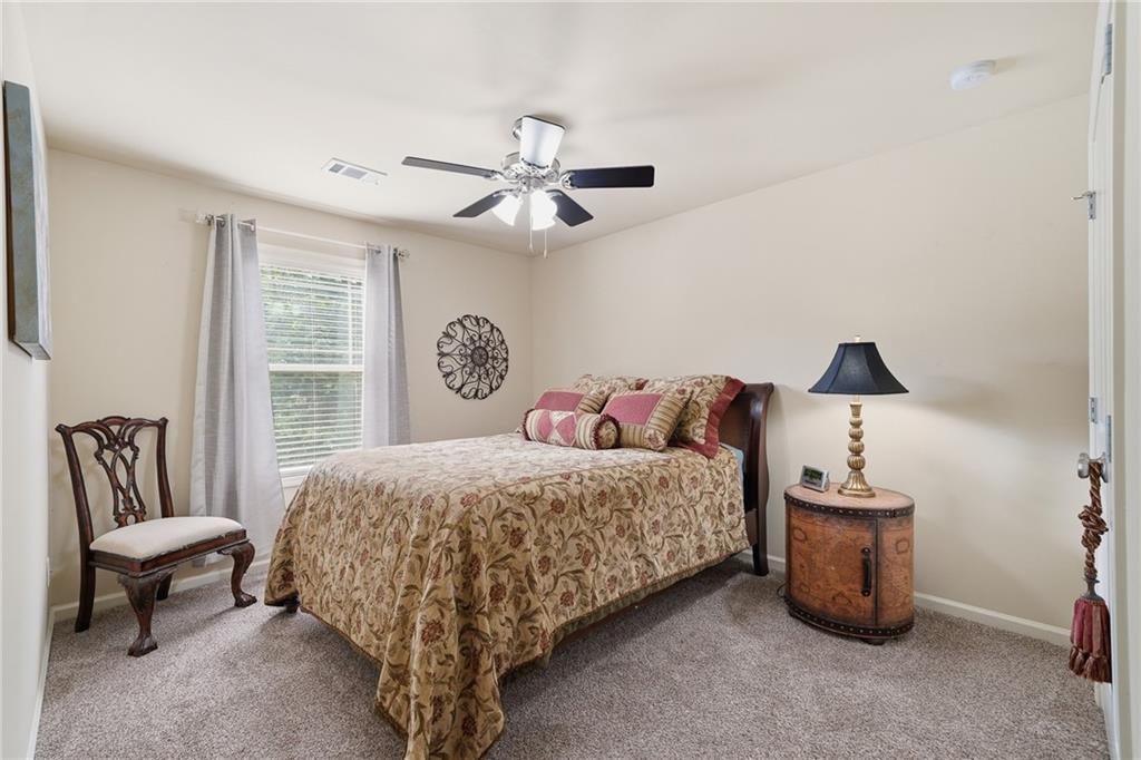 608 Myers Gate Road Ball Ground, GA 30107 - Photo 24 of 31 a bedroom with a bed and a chandelier