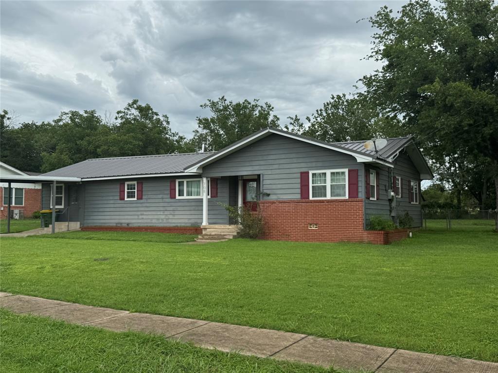 a front view of a house with yard and green space