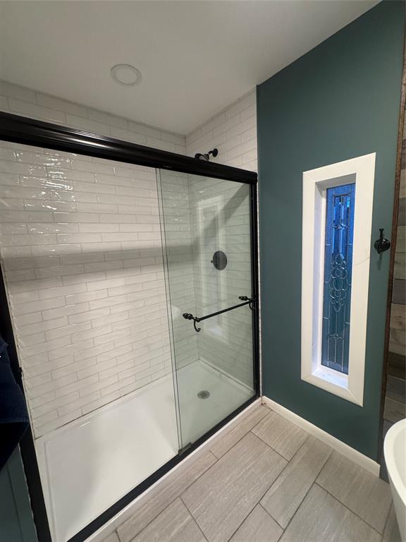 708 West 1st Street Hico, TX 76457 - Photo 17 of 24 a bathroom with a glass shower door and a window