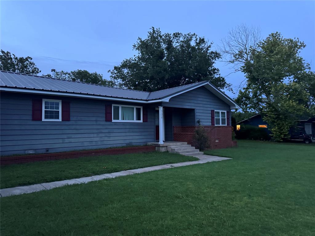 708 West 1st Street Hico, TX 76457 - Photo 3 of 24 a front view of a house with a garden