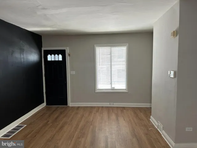 a view of empty room with window and wooden floor