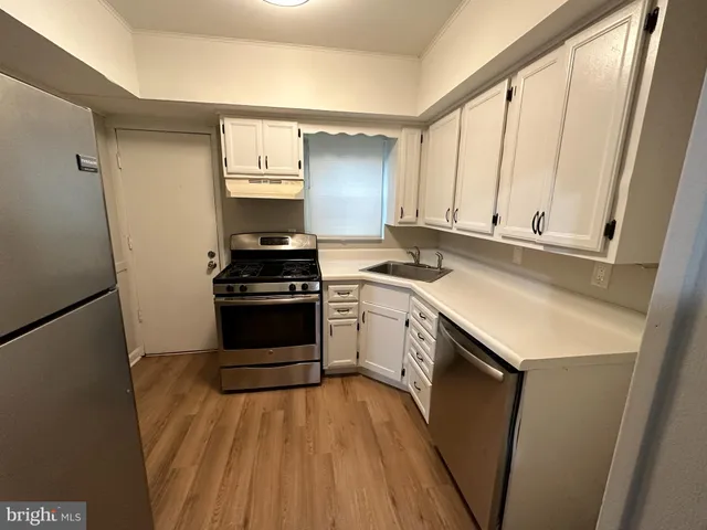 a kitchen with a sink a stove and cabinets