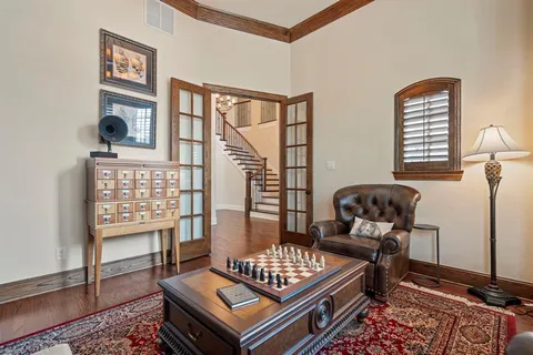 a living room with furniture a bookshelf and a large window