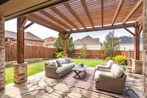 a living room with patio furniture and a garden