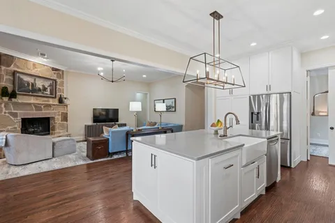 a view of a dining room and livingroom with furniture wooden floor a chandelier